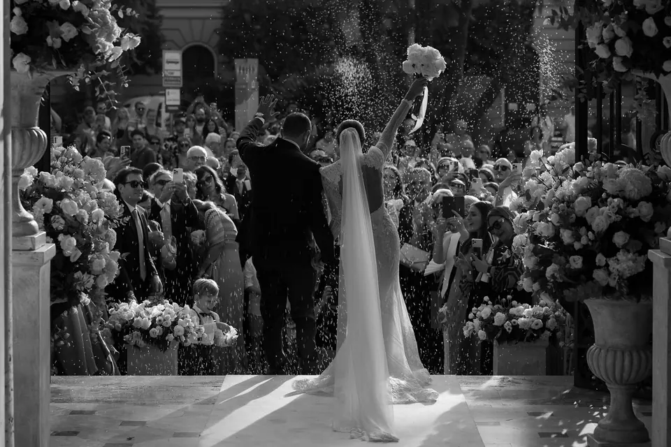 Schwarzweißfoto: Die Braut erreicht zwischen den Gästen den Altar.