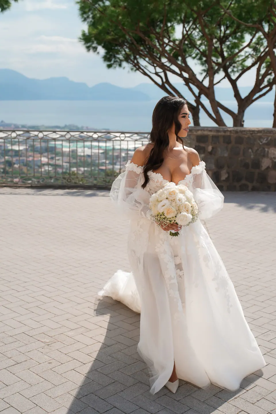 Bride walking along the villa’s terrace, her gown catching the breeze.