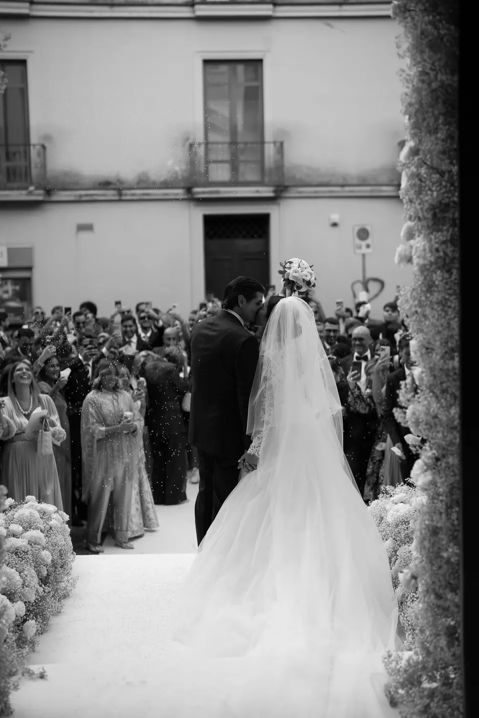 Black and white photo of the bride entering the church among the guests