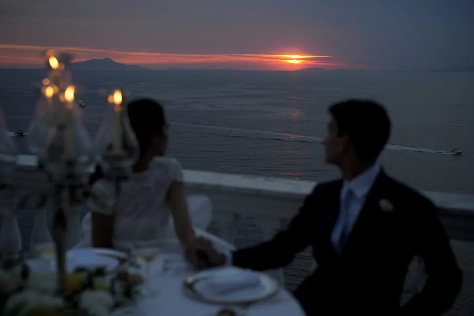 Couple dining at sunset, warm golden light embracing the moment at Grand Hotel La Cocumella.