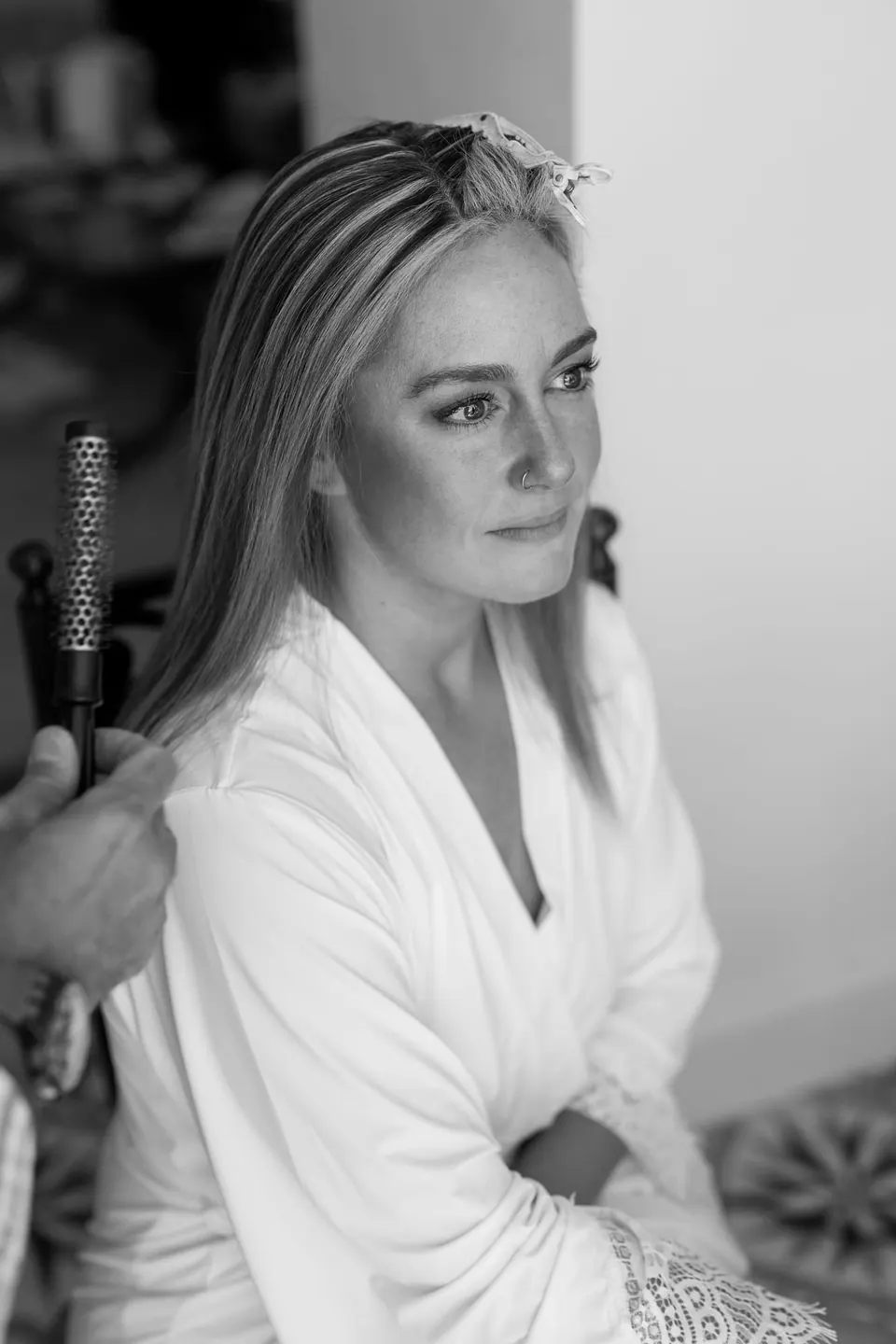 Black and white photo of the bride in her robe during hair and make-up
