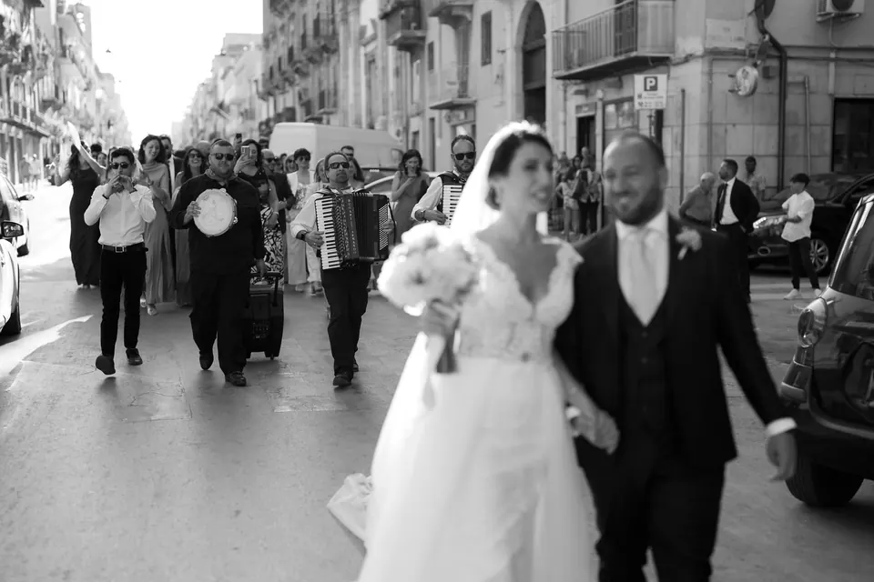 Bride and groom walking through the streets of a Sicilian town.