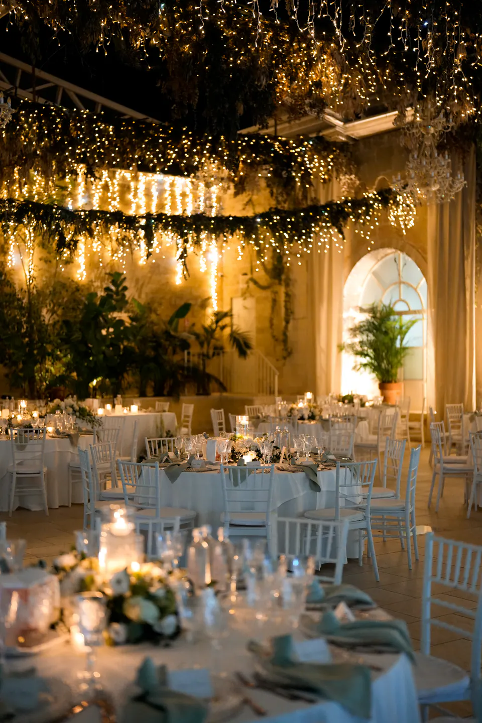 I tavoli della cena sotto il verde sospeso e centinaia di luci calde a Tenuta Sant'Elia.