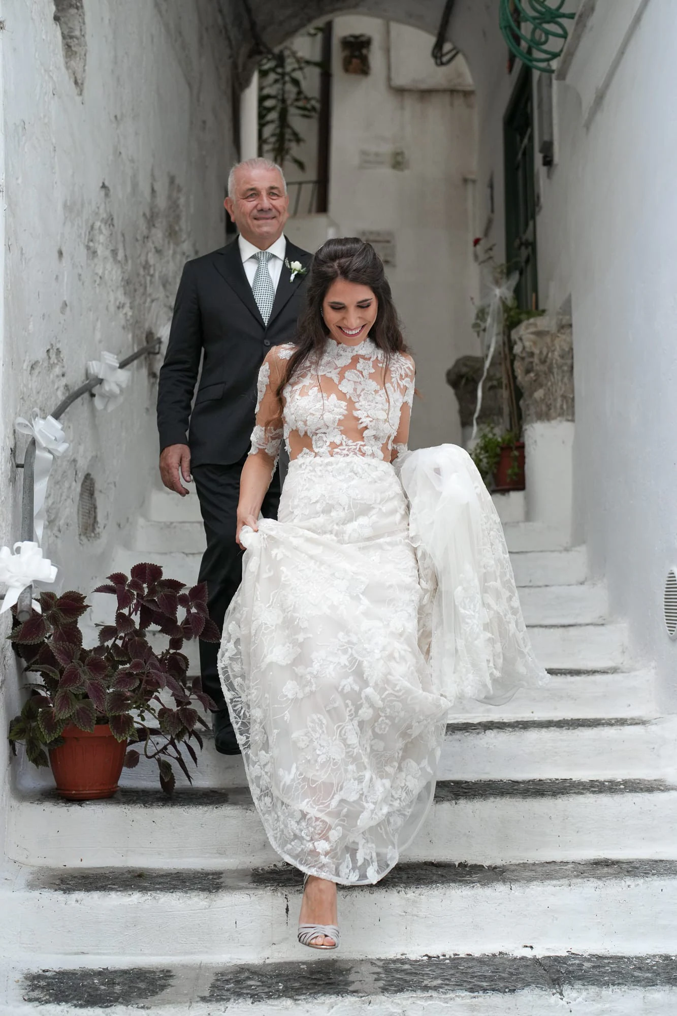 Bride coming down whitewashed steps with her father
