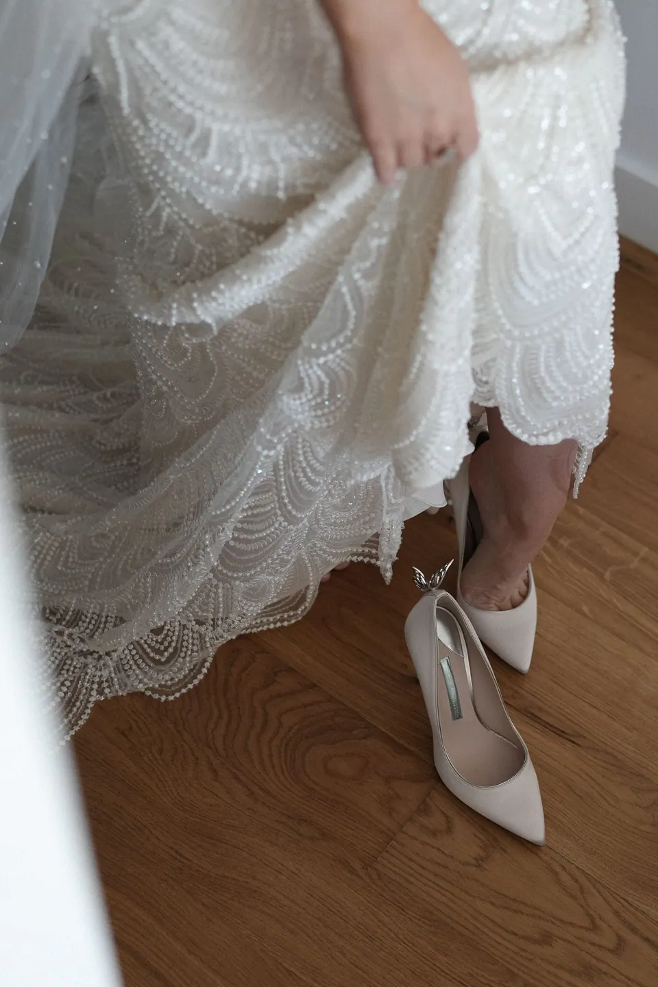 Bride lifting her lace gown to show her shoes