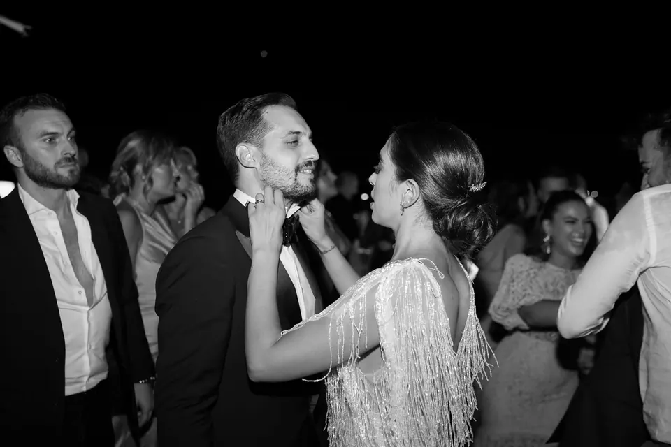 Bride and groom dancing among guests at the evening party.