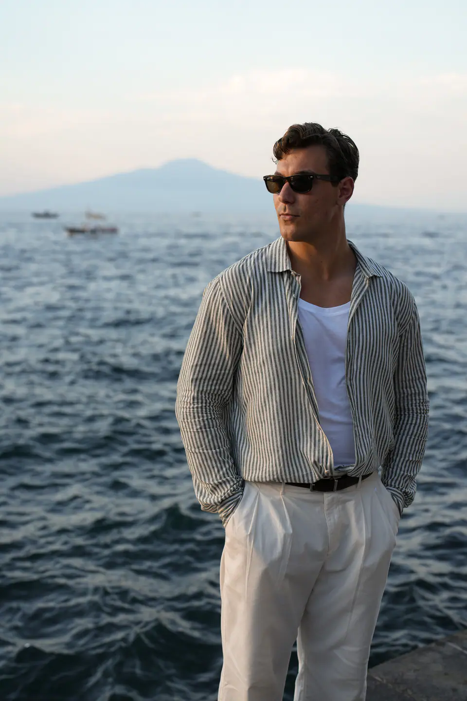 Groom in a linen shirt by the sea, Vesuvius behind him.