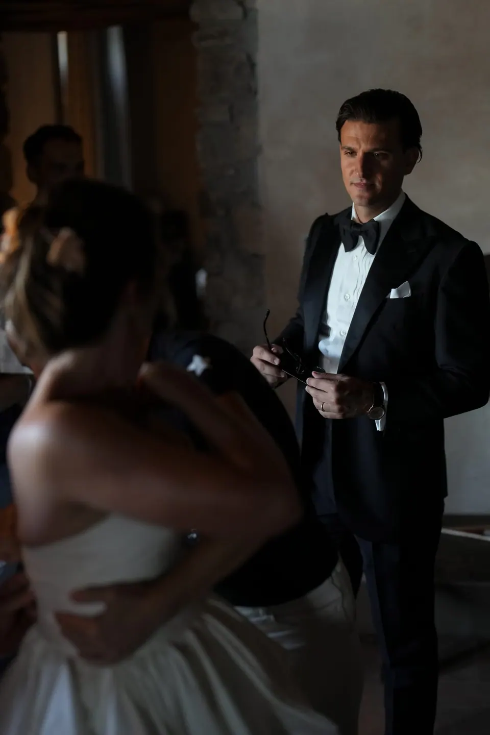 Lo sposo guarda verso la sposa nella penombra del castello.