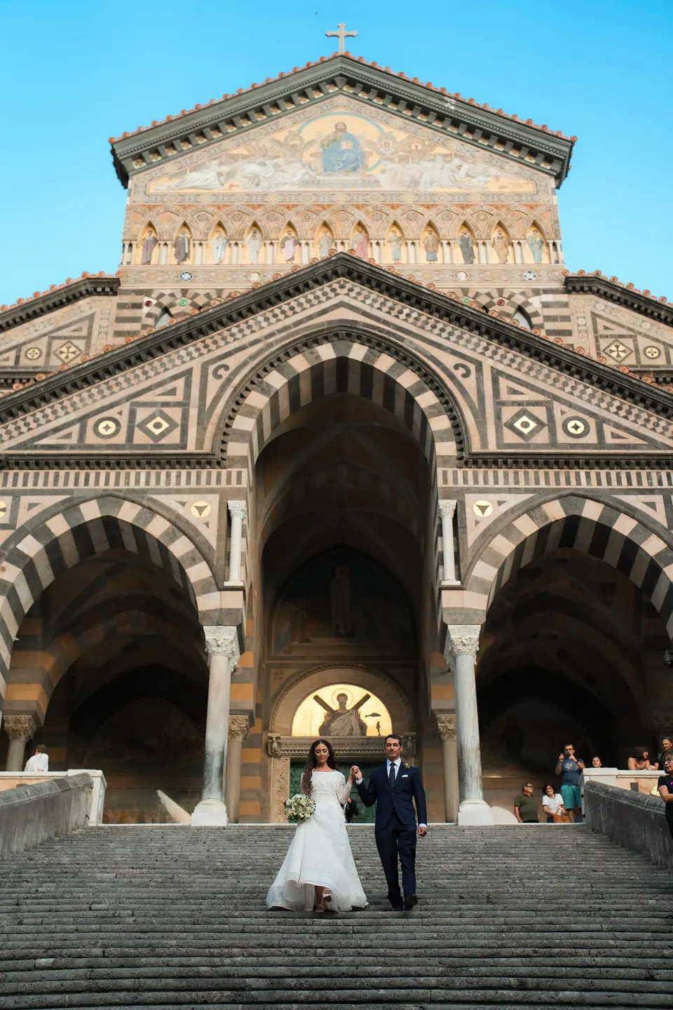 View of Amalfi Cathedral’s grand entrance with the bride and groom at the top of the stairs.