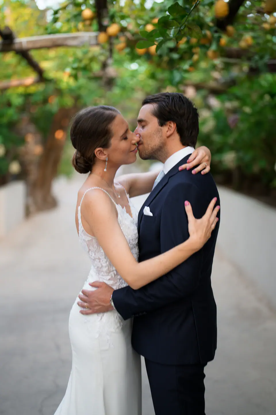 Groom kissing the bride under the lemon trees.