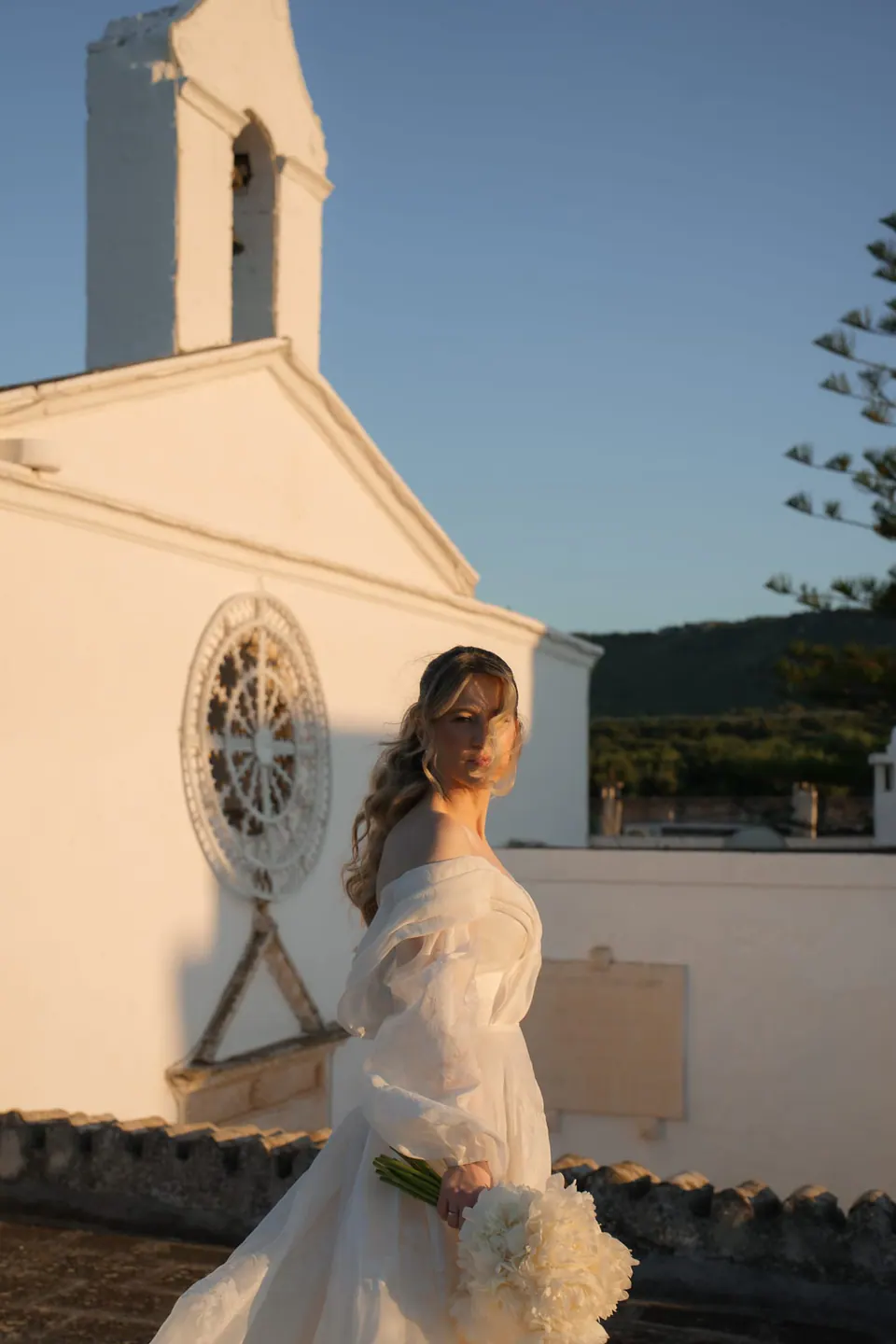 La novia camina por calles soleadas.