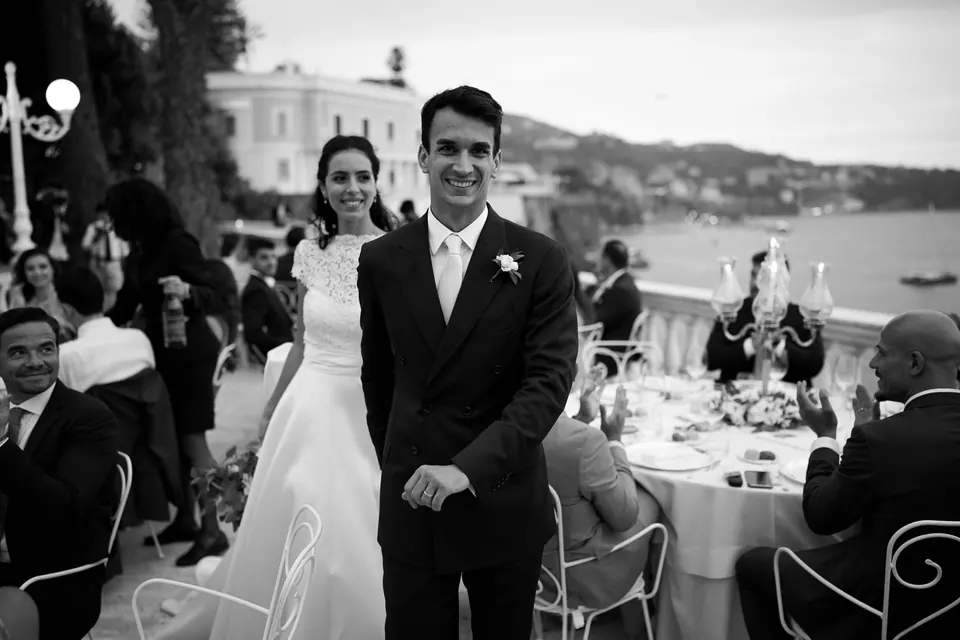 Bride and groom among the dinner tables on the terrace of La Cocumella