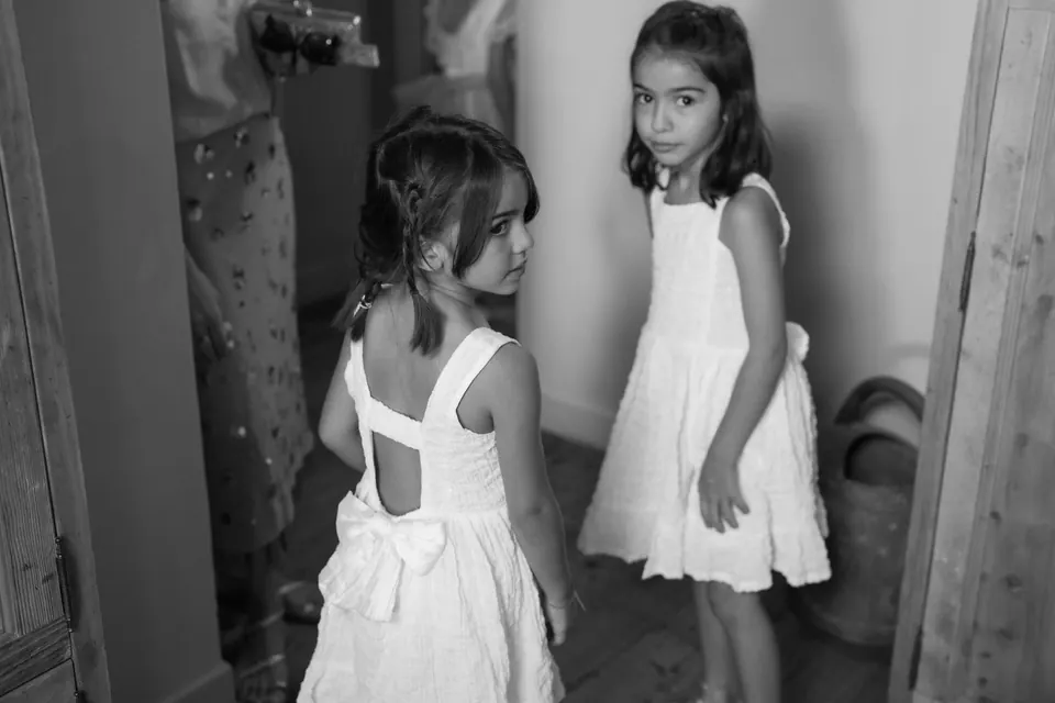 Black and white photo of two flower girls in white dresses