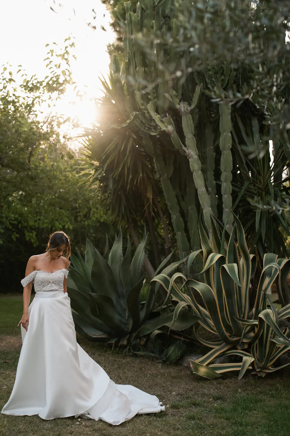 Bride walking through the garden at sunset, light illuminating her gown.