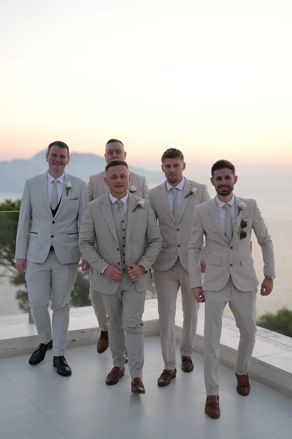 Sposo e testimoni in abiti beige coordinati sulla terrazza