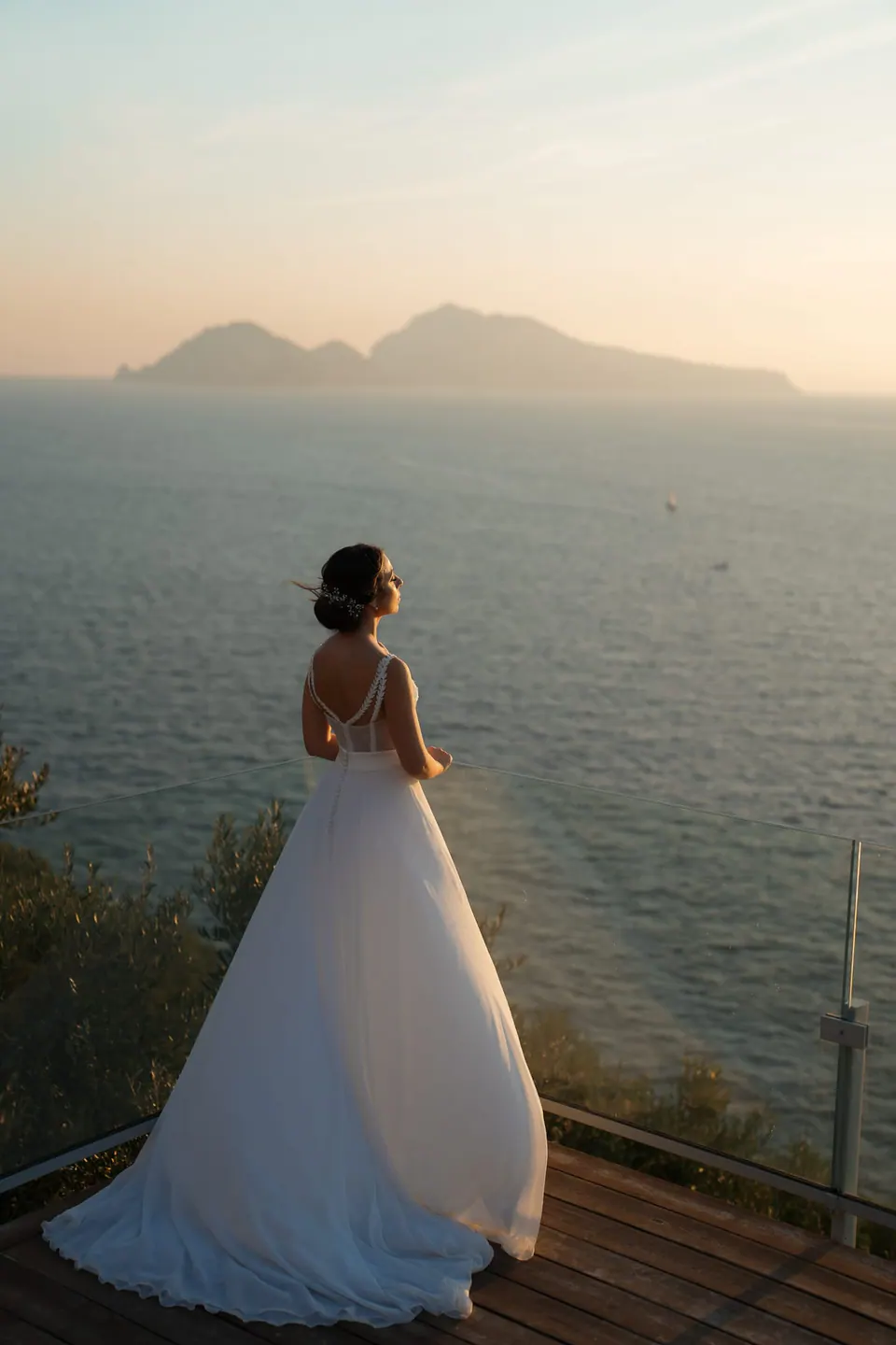 Bride gazing at the horizon, standing on the villa’s terrace overlooking the Mediterranean.