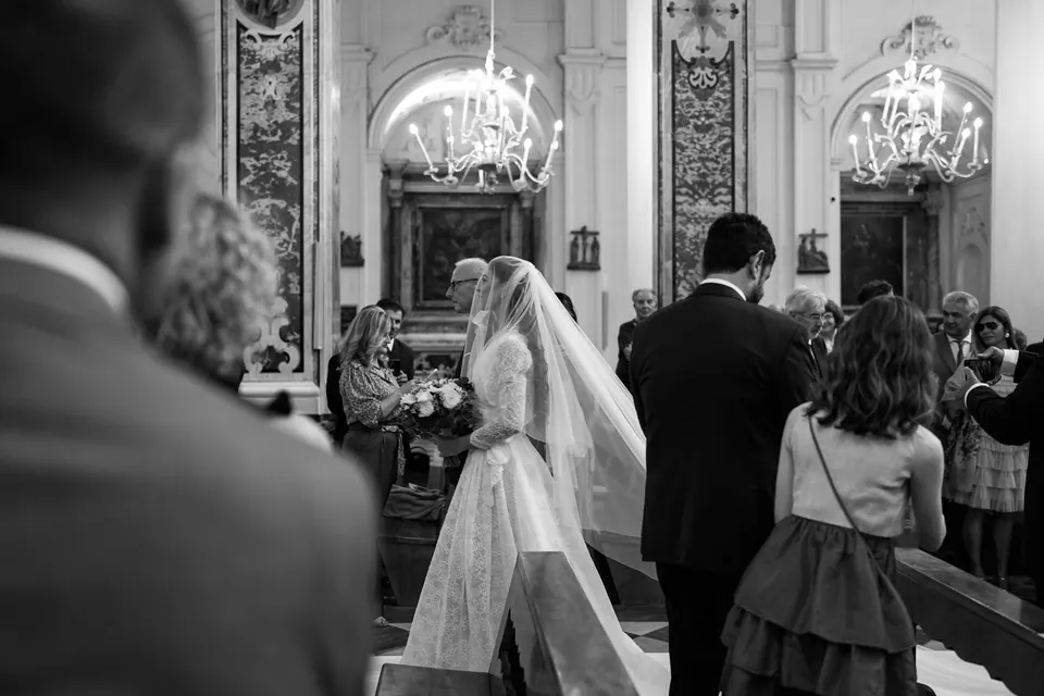 Black and white photo of the bride arriving at the altar inside the Duomo di Amalfi.