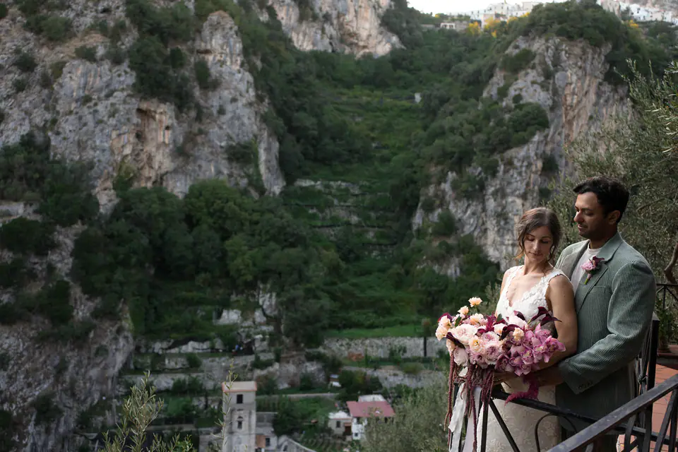 Couple on a balcony above a green valley on the Amalfi Coast.