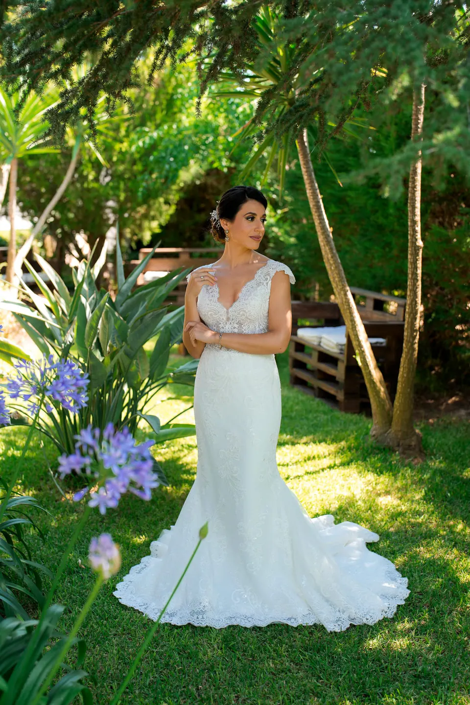 Bride in the garden of Tenuta Cala Muletti among agapanthus