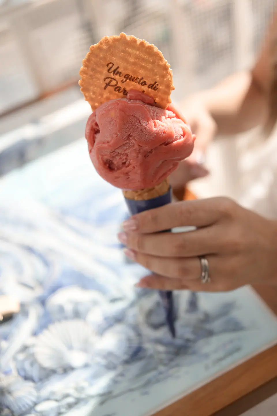 Close-up of a gelato cone in the bride's hand, her ring catching the light.
