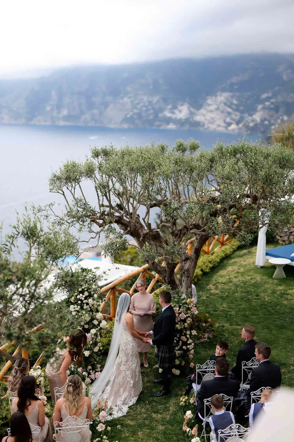 Vista dall'alto della cerimonia in giardino a Villa Milù, la Costiera Amalfitana e il mare sullo sfondo.