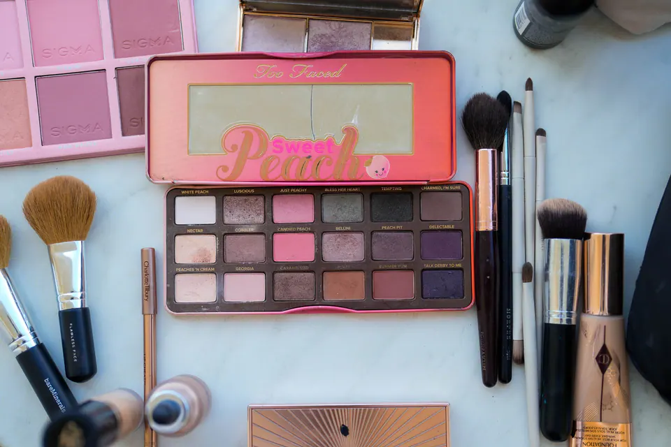 Make-up palette and brushes on a wooden table on the wedding morning.