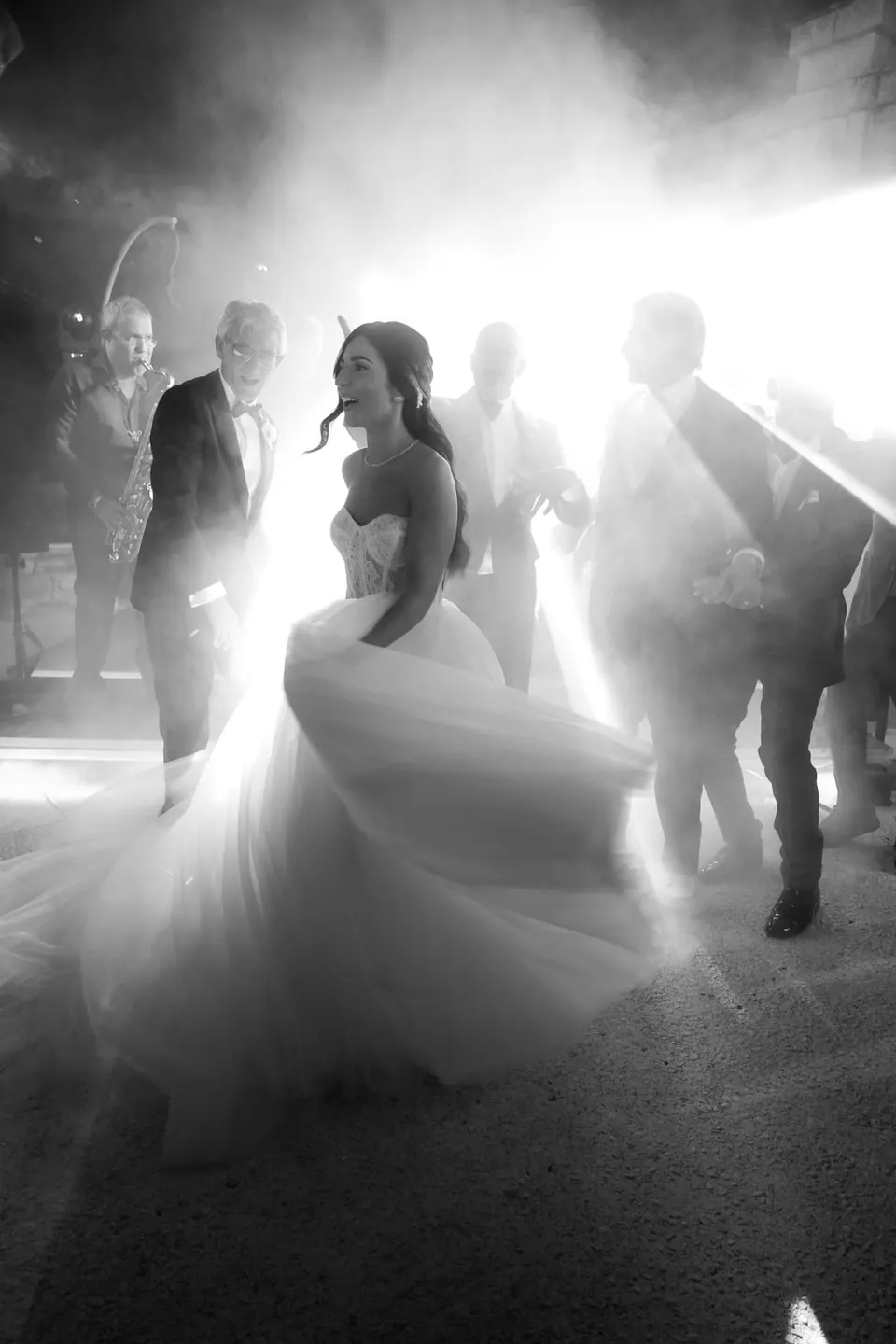Black and white photo of the couple dancing under a spotlight at the reception.