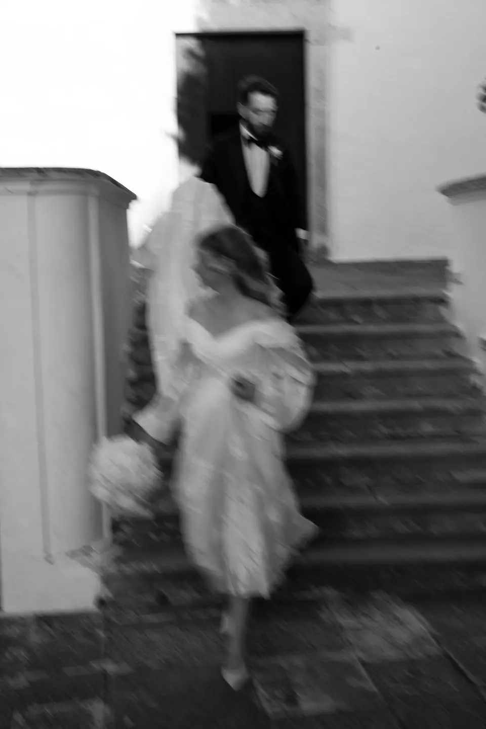 Los novios bajan la escalera tras la ceremonia, un momento alegre y espontáneo.
