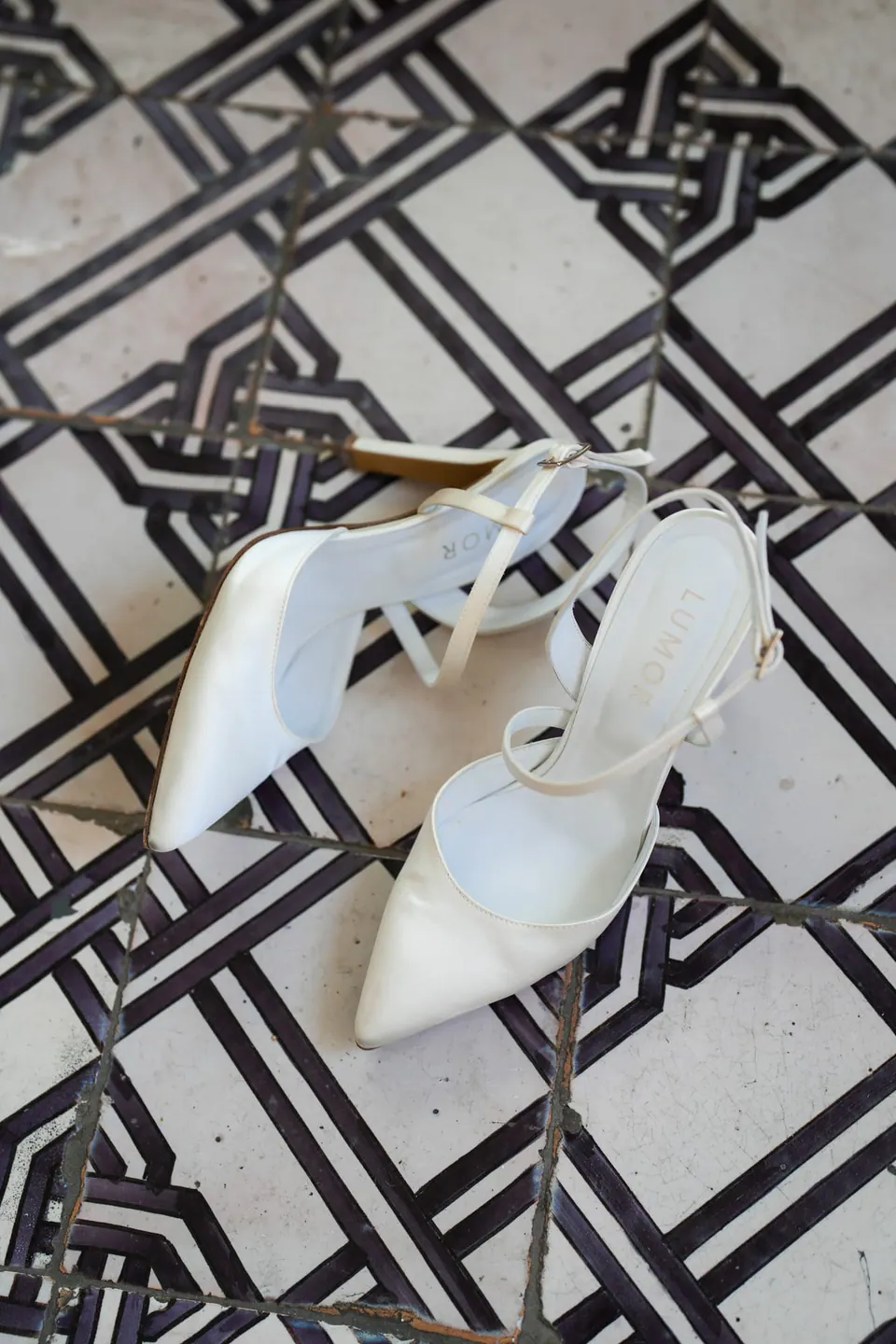 Bridal shoes on black and white geometric tiles.