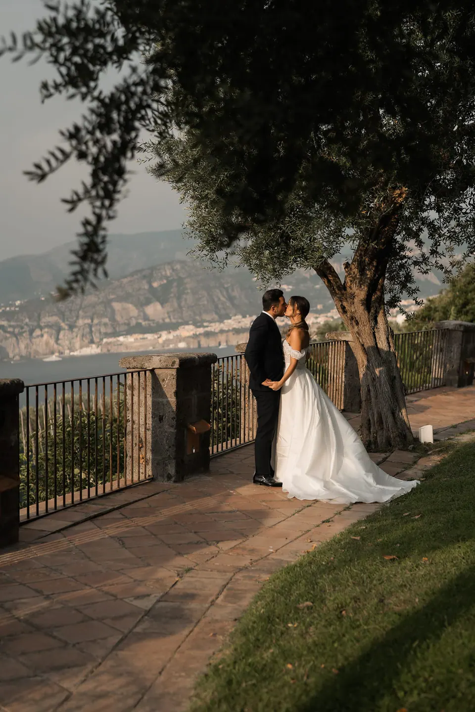 Bride and groom kissing on a terrace above the Bay of Sorrento