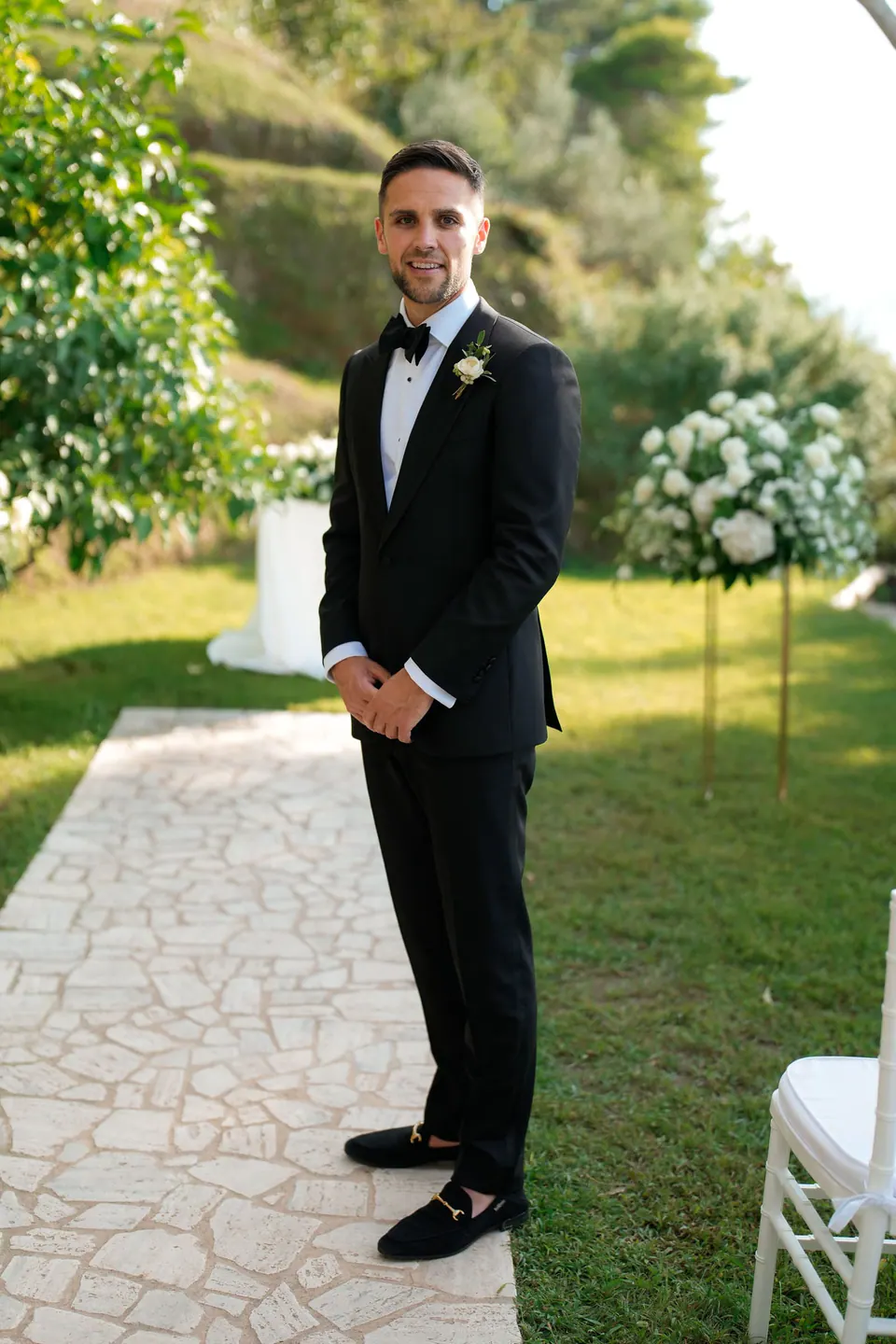 Groom in a black suit on the terrace among the greenery, Relais Blu.