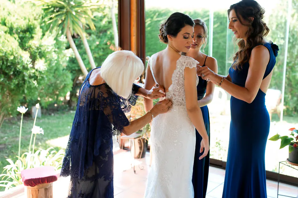 Bridesmaids helping the bride get ready, joyful morning preparations.