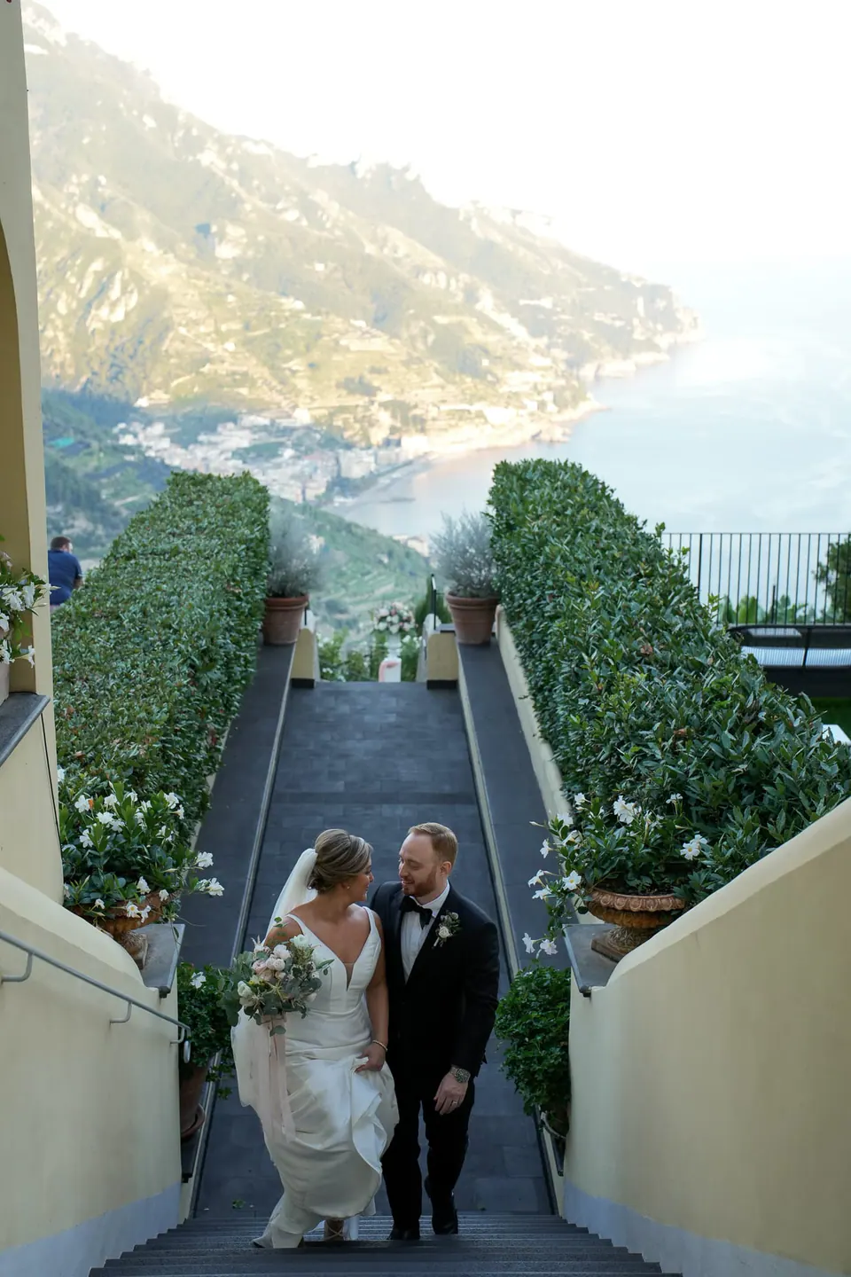 Bride and groom walking down the garden steps towards the sea at the Belmond Hotel Caruso