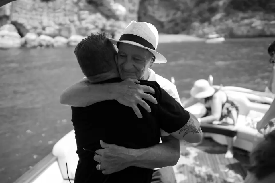 Black and white photo of a friend hugging him after the proposal.