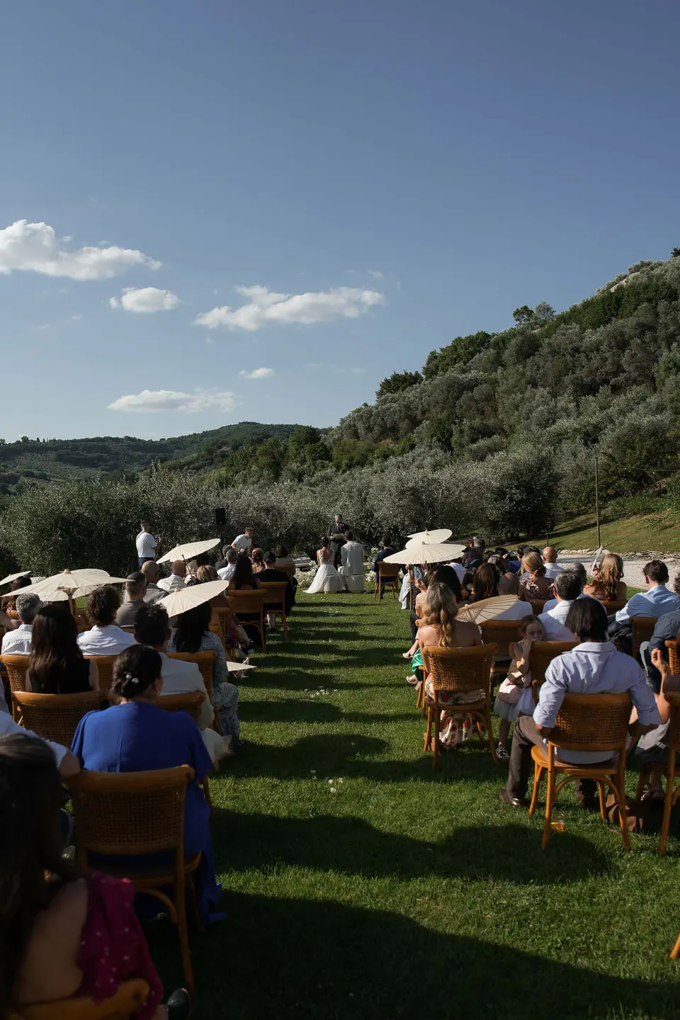 Guests seated on the lawn for the ceremony, the hills behind