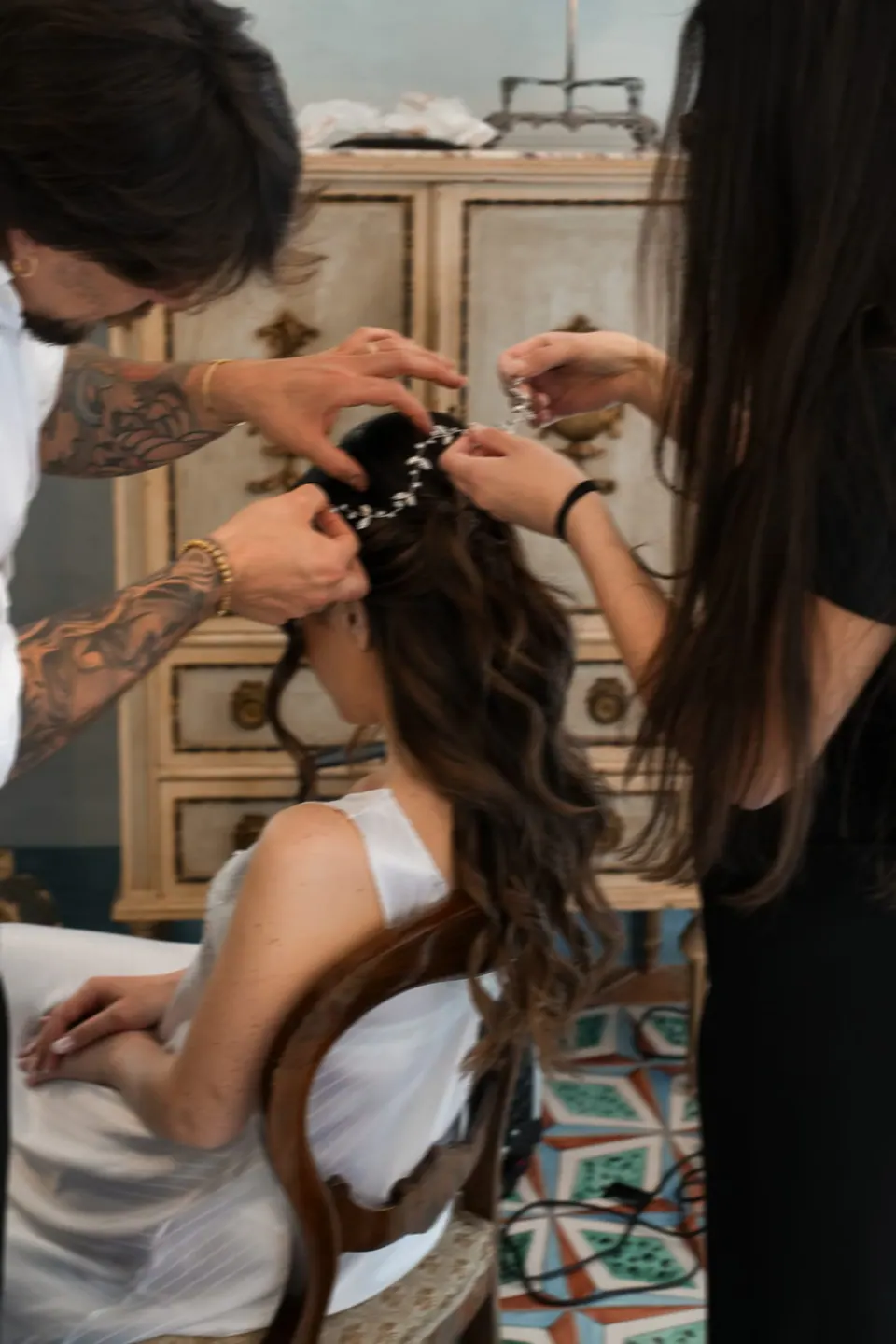 La peluquera sujeta el pelo de la novia durante los preparativos en Tenuta dell’Orso.